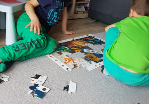 Juliuszek wspólnie z bratem układa puzzle